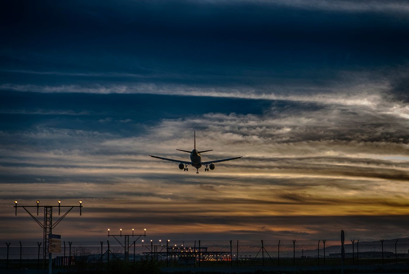 Vliegtuig in de landing boven een verlichte landingsbaan in de avond